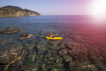 Traveling by kayak along the sea coast on a sunny day.