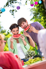 Happy people eating watermelon