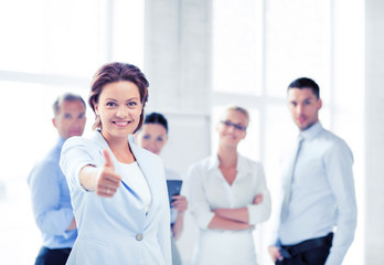 businesswoman in office showing thumbs up