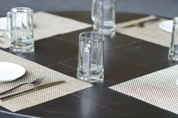 empty glass mug, cutlery and white dish