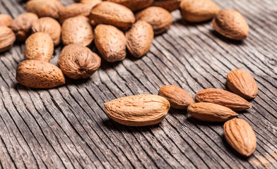 Tasty almond nuts on rustic wooden background