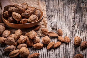 Tasty almond nuts on rustic wooden background