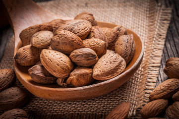 Tasty almond nuts on rustic wooden background