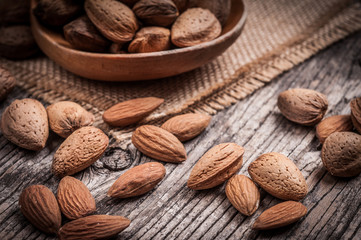 Tasty almond nuts on rustic wooden background