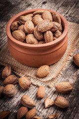 Tasty almond nuts on rustic wooden background