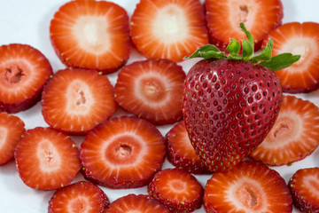 Big tasty strawberry lies on sliced strawberries