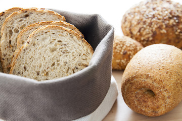 Cestino con pane a fette su tagliere con pane integrale