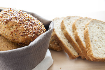 Cestino con pane integrale su tagliere di legno con pane a fette