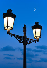 Fototapeta na wymiar old street light and moon by night. 
