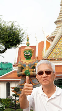 Asian senior man with green giant in temple of dawn, Bangkok, Th