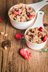 Homemade granola with dried berries on a wooden background