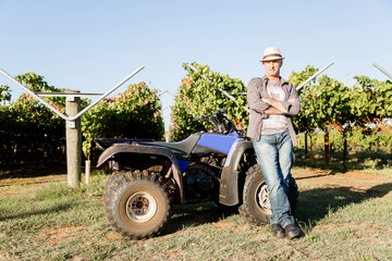 Fototapeta premium Man standing next to truck in vineyard