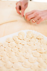 Orecchiette raw homemade and blurred hands working 