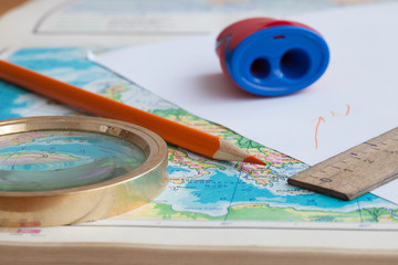 Map, pencil and magnifying glass