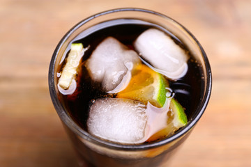 Cocktail with lime slices and ice blocks on wooden table, top view