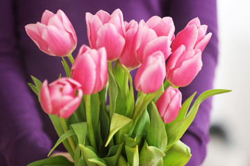 Bouquet of pink tulips in hands of beautiful young  girl, close up