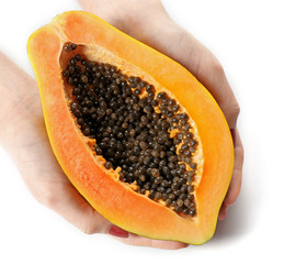 Female hands holding a halved papaya on white background