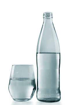 Bottled water with a glass on the grey background, close up