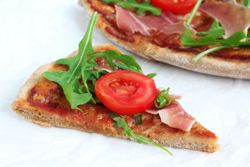 Pizza with Porsciutto, cherry tomatoes and rocket salad