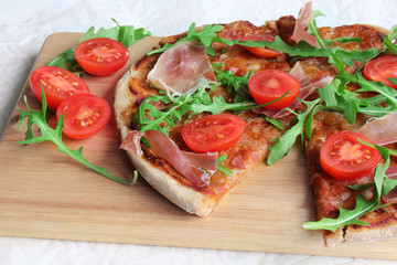 Pizza with Porsciutto, cherry tomatoes and rocket salad