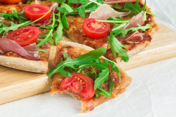 Pizza with Porsciutto, cherry tomatoes and rocket salad