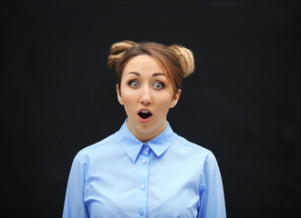 Young blond girl against blackboard.