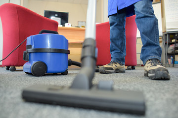 Closeup of male feet and vacuum cleaner