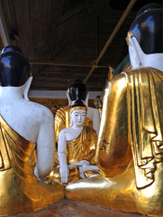 Gold and white Buddha statues at the Shwedagon Pagoda in Yangon,