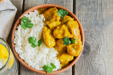 chicken curry with rice on a wooden surface - obrazy, fototapety, plakaty