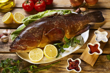 fish on a tray with garlic and lemons