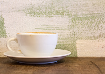 Hot coffee in a white cup on table