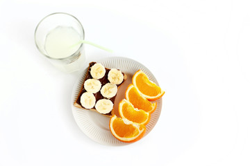 sweet oranges and banana on bread with chocolate and fresh drink