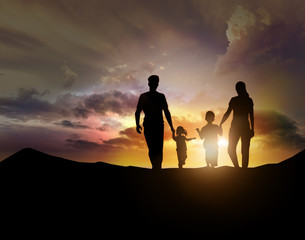 silhouette of family facing the sunset