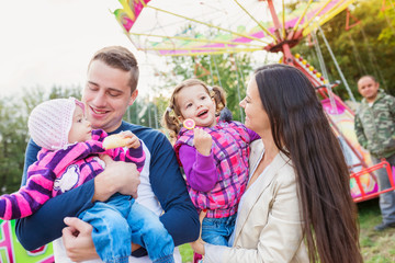 Family with little girls enjoying time at fun fair