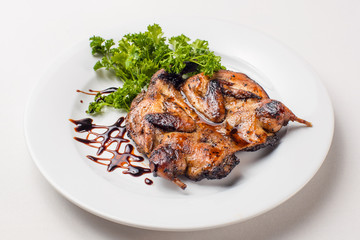 quail roasted in a dish on a white background