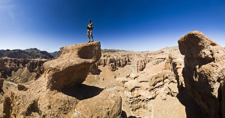 man on a cliff in desert canyon