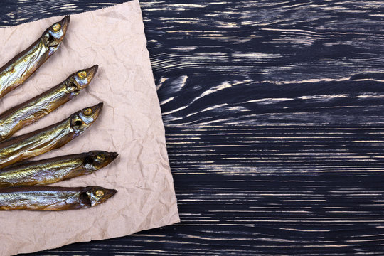 Smoked  capelin on vintage wooden background, top view