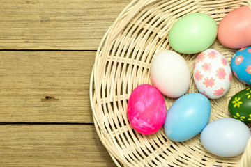 Fototapeta na wymiar Easter eggs in the basket on wood background