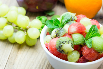 Naklejka na ściany i meble fruit salad with strawberries, oranges, kiwi, grape and watermel