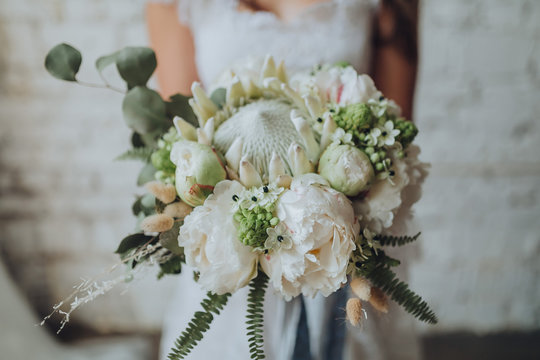 girl in a white wedding dress holding a bouquet of white flowers