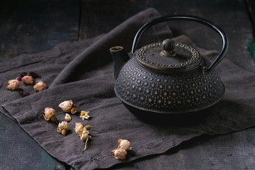 Obraz na płótnie Canvas Black teapot with dry roses