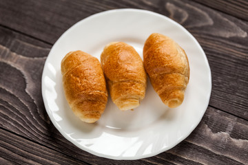 small croissant on wooden background