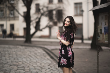 Fototapeta premium Beautiful brunette young woman posing on the street in old city