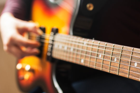 woman's hands playing electric guitar