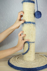 Children hand sharpening his claws on a scratching post like a cat