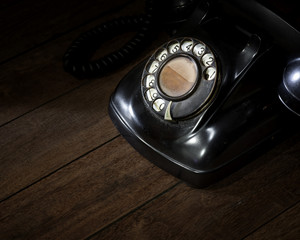 Old telephone on wood background.