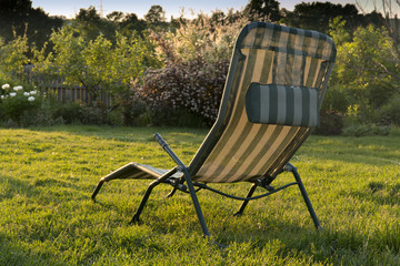 chaise longue in the garden at sunset background