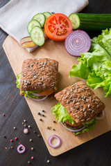 fresh home made burgers with grain bread on wooden background