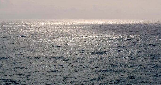 cheggie di sole riflesse sul mare mosso al mattino presto
