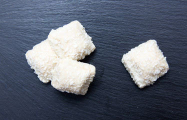 Cakes with coconut on top slate seen from above